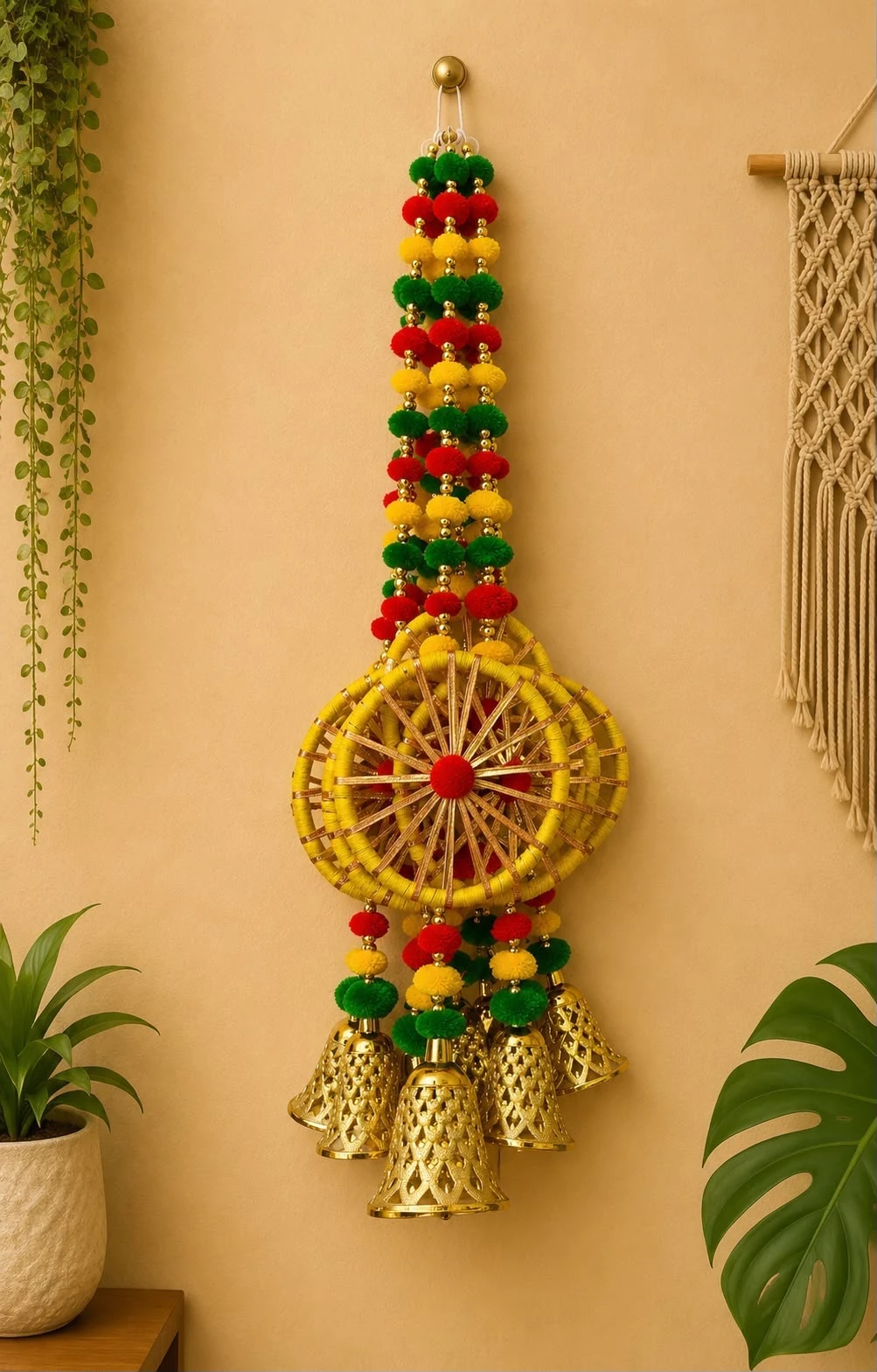 Double ring woven wheel Diwali wall hanging with red, yellow and green pom-pom strands and hanging gold bells